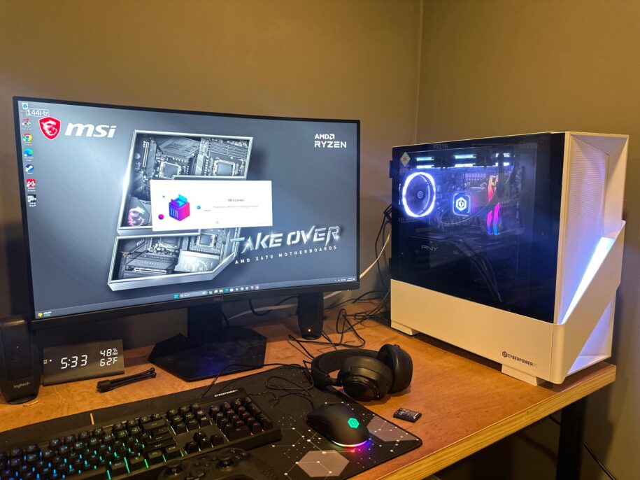 Picture of a gaming PC on a desk. The PC is in a white case illuminated by a diagonal white LED light.