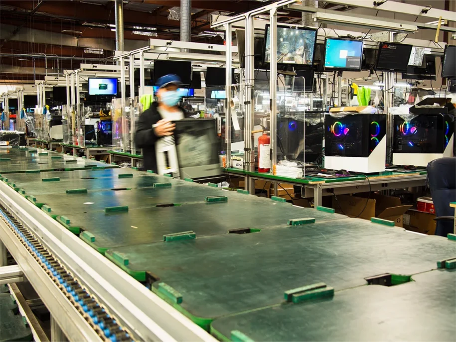 CyberPower employee carries gaming PC case through production area.